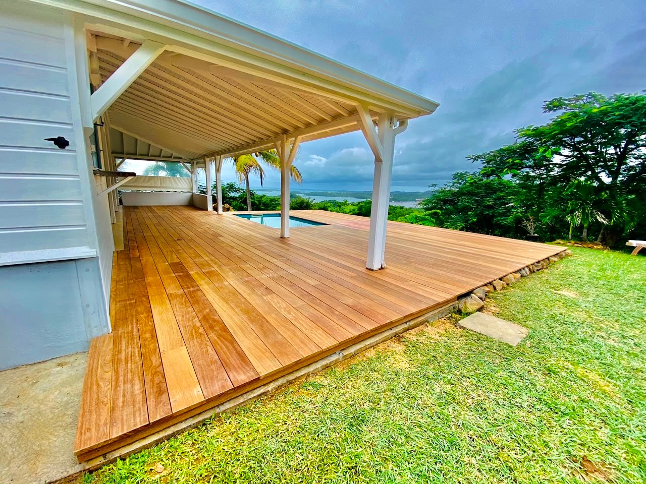 Après les travaux, grand deck en bois autour du bassin et de la terrasse couverte