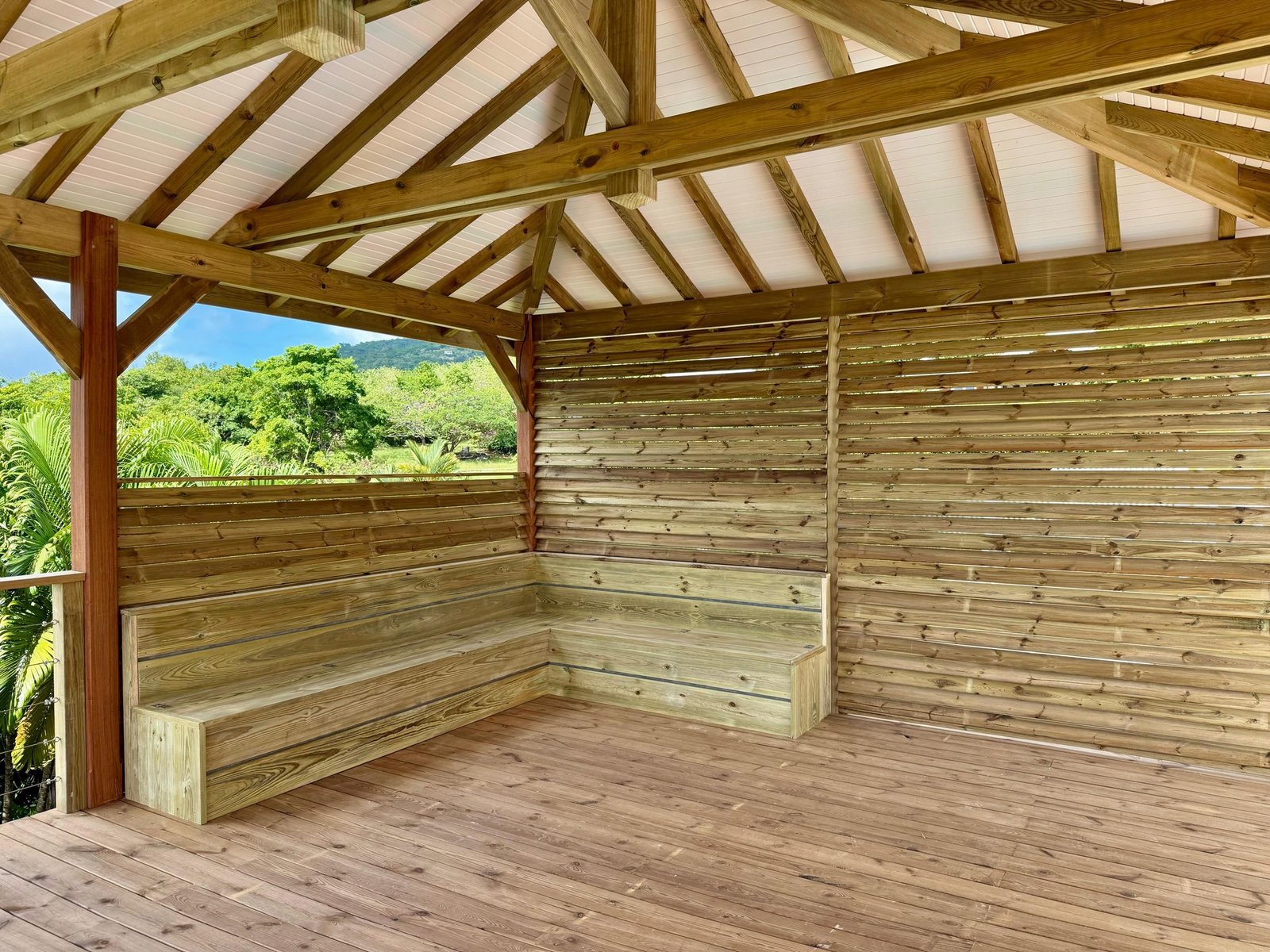 Charpente apparente et aménagement intérieur d’un carbet en bois