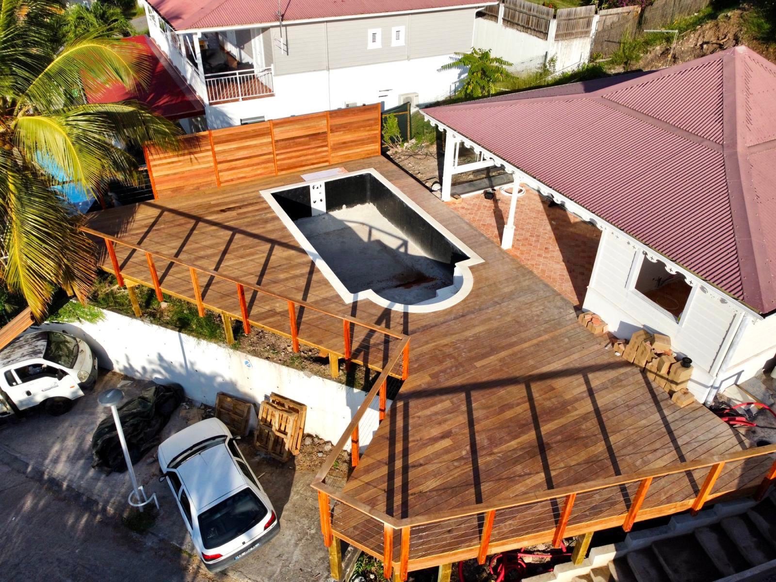 Vue aérienne d’un vaste deck en bois autour d’une piscine